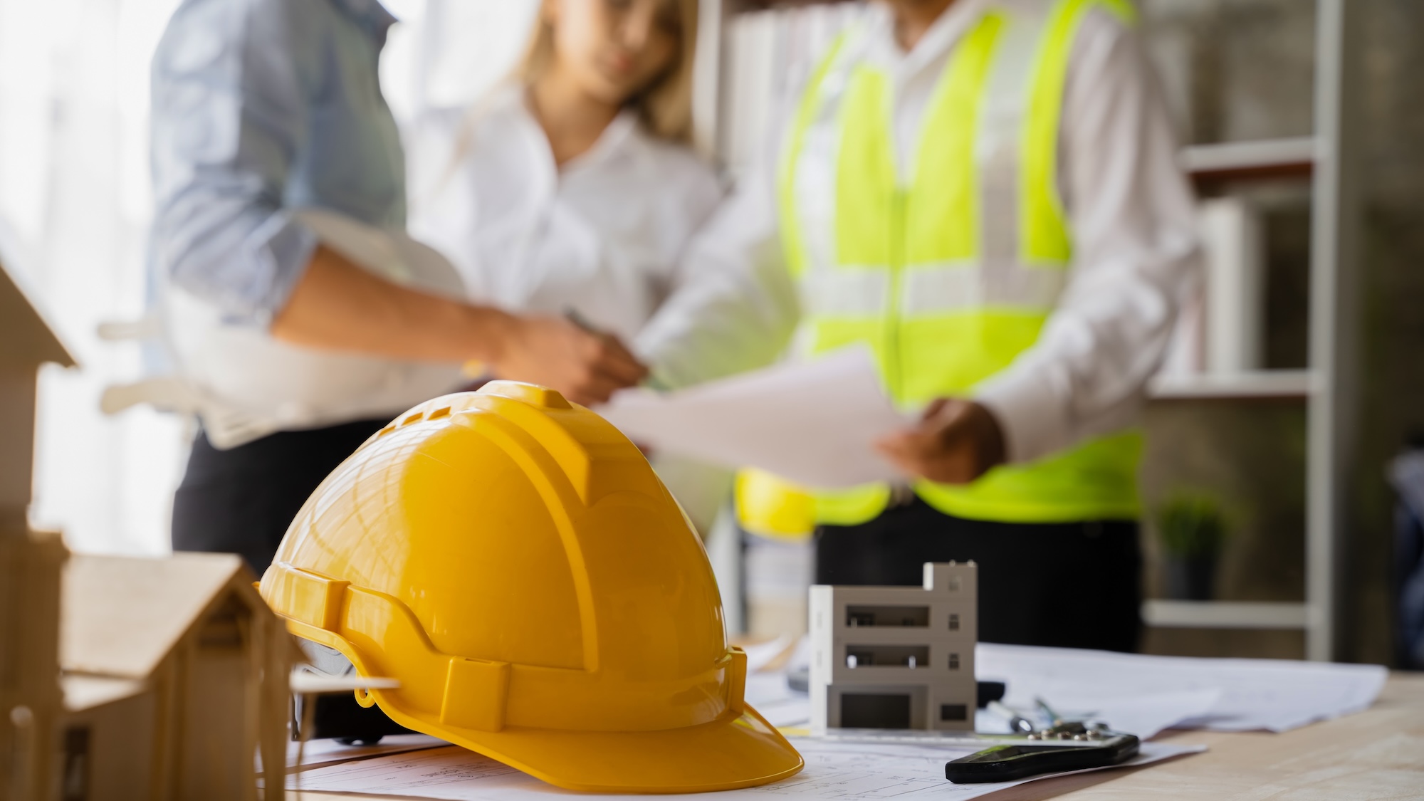 Professional general contractors planning construction project with blueprints showcasing modern project coordination and management