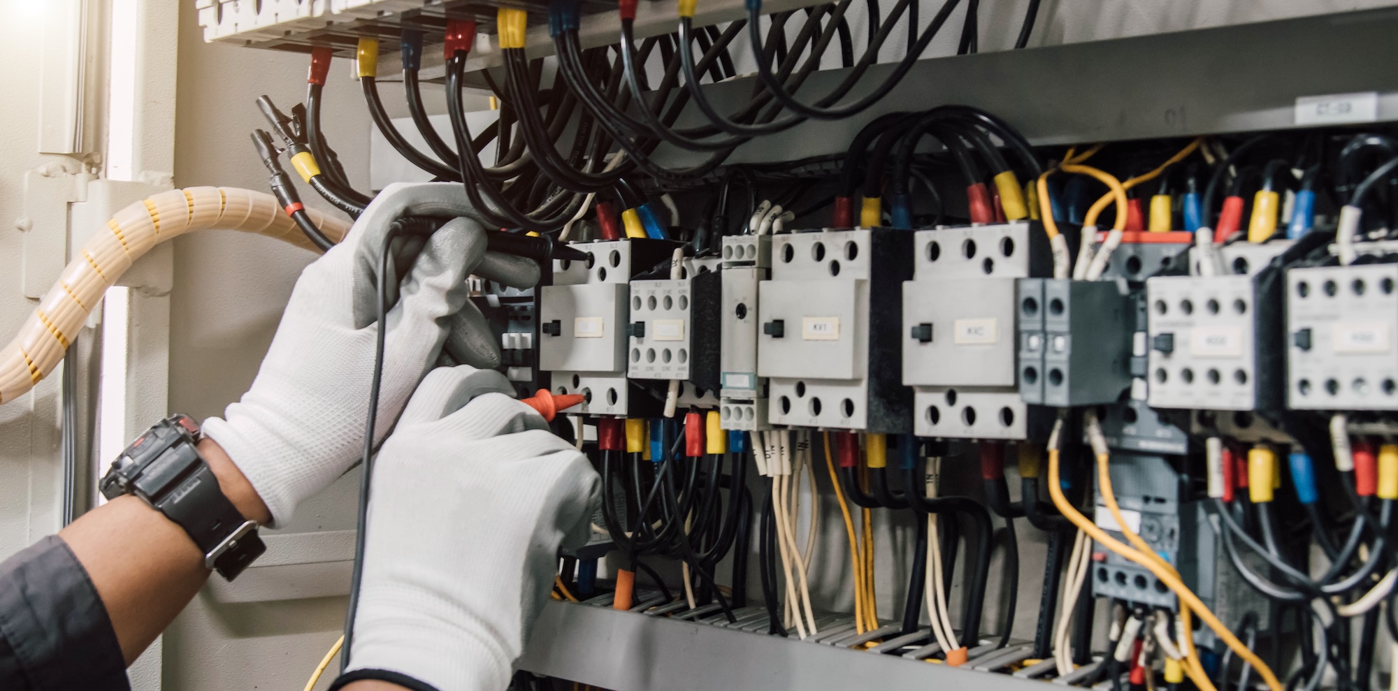Skilled electrician working on commercial electrical systems showcasing field service operations and technical expertise