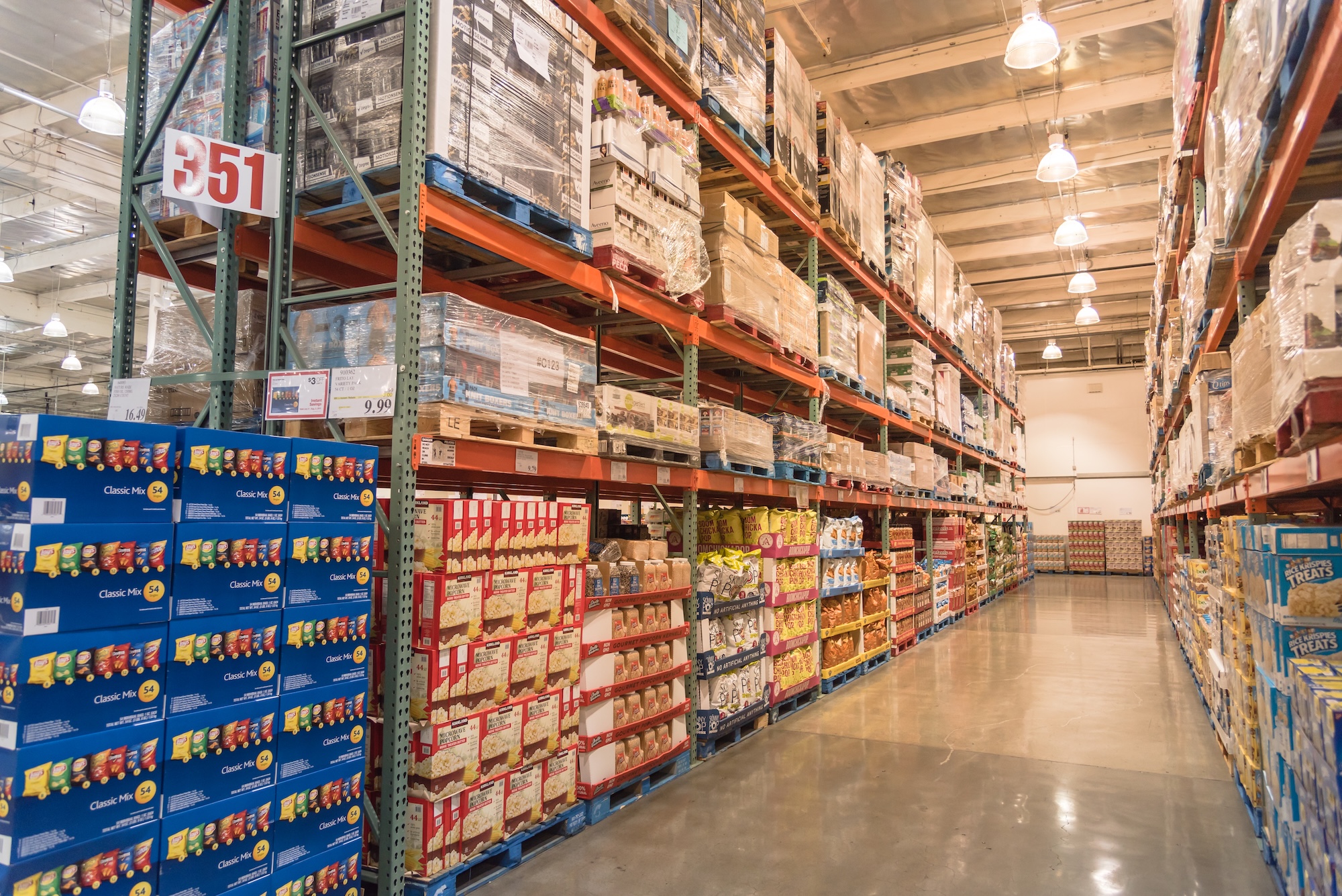 Large-scale distribution warehouse with industrial shelving storing non-durable goods including food products, snacks, and packaged consumables for wholesale distribution operations